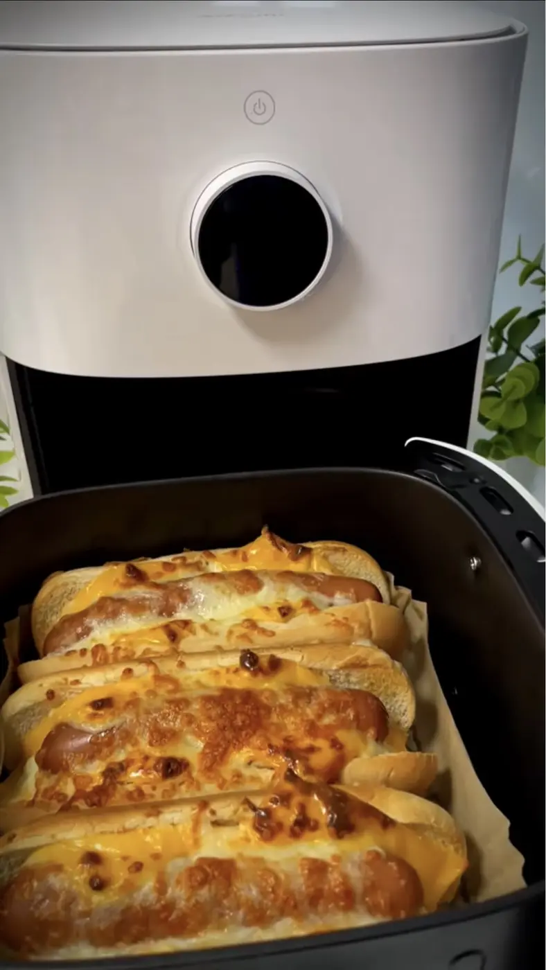 Perritos calientes con queso gratinado dentro de una freidora de aire