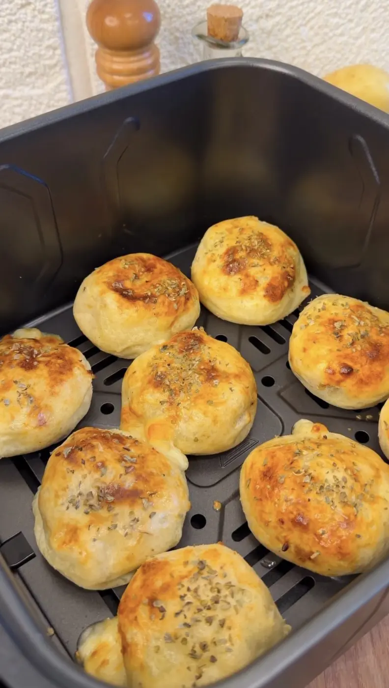 Panecillos rellenos dorados dentro de la cesta de una freidora de aire